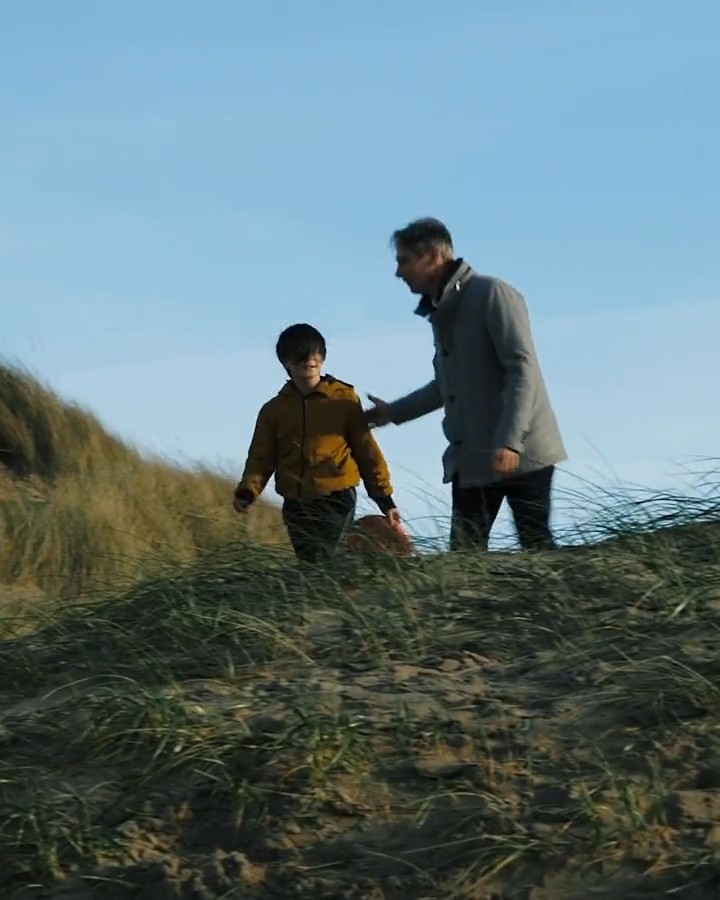 Man loopt over een strand tijdens de opnames van een documentair portret.